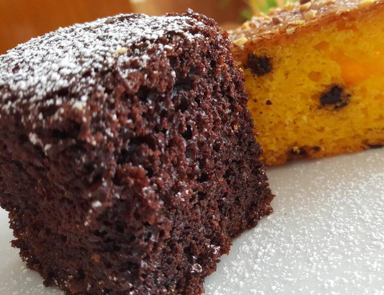 Due fette di torta soffice, una al cioccolato, l'altra all'arancia, con zucchero a velo.