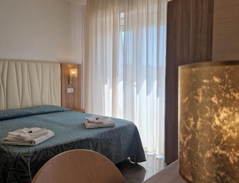 Bright room with cozy bed, light curtains, and a relaxing atmosphere.