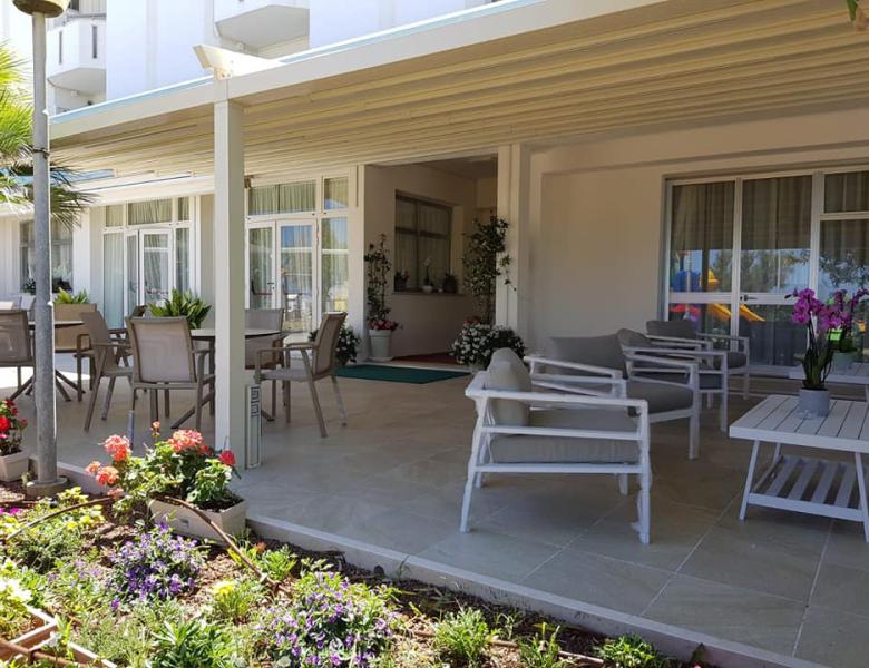 Elegante terrazza con fiori colorati e sedie accoglienti, atmosfera rilassante.