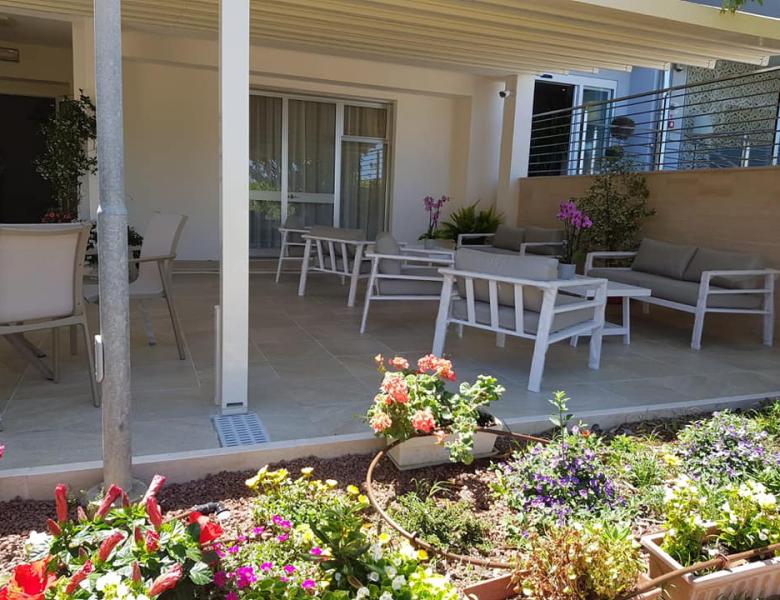 Terrazza accogliente con fiori colorati e arredo moderno, atmosfera rilassante.